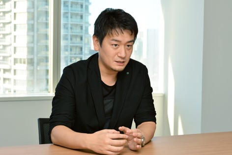 中田敦がインタビューに答えている写真です。