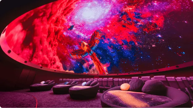 A domed theater with a hemispherical screen showing colorful birds flying in space.
